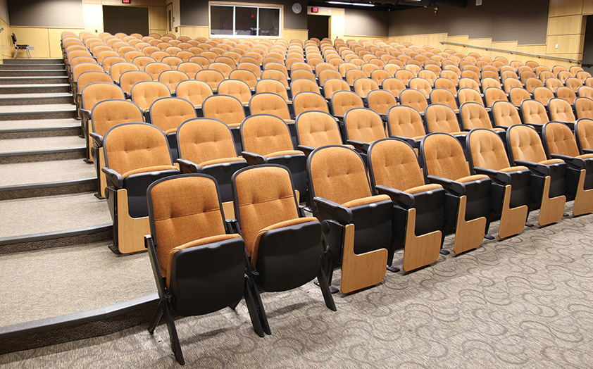 Stacking Quattro portable chairs in school auditorium