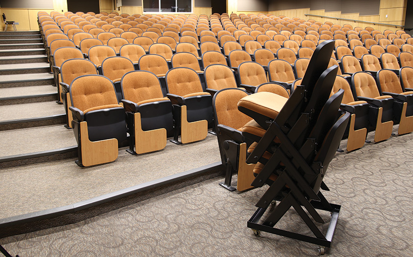 Portable chairs in school auditorium stacked