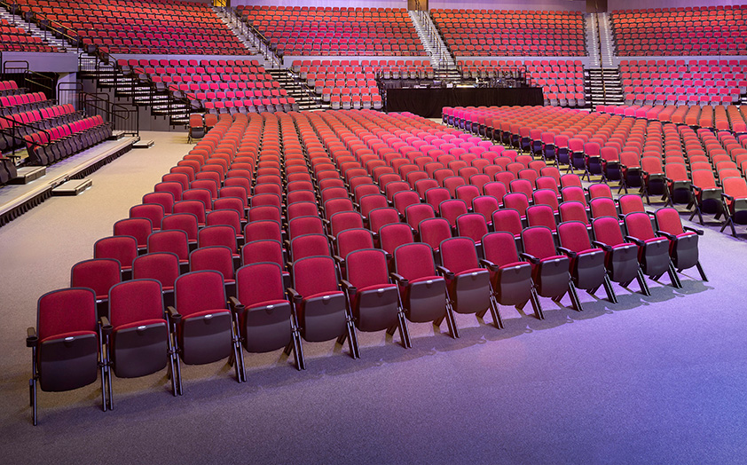 Stacking Quattro portable audience chairs in theater